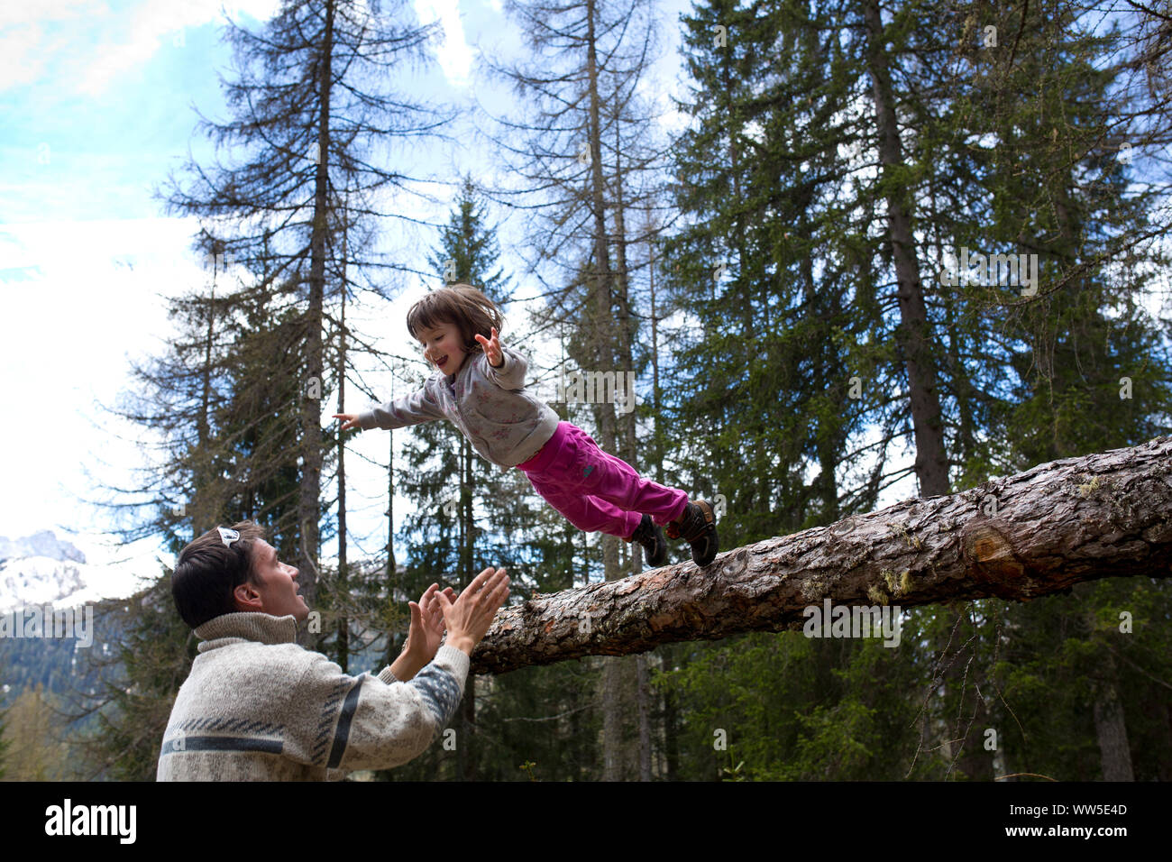 30-40 years old father catching 3-6 years old jumping daughter Stock Photo