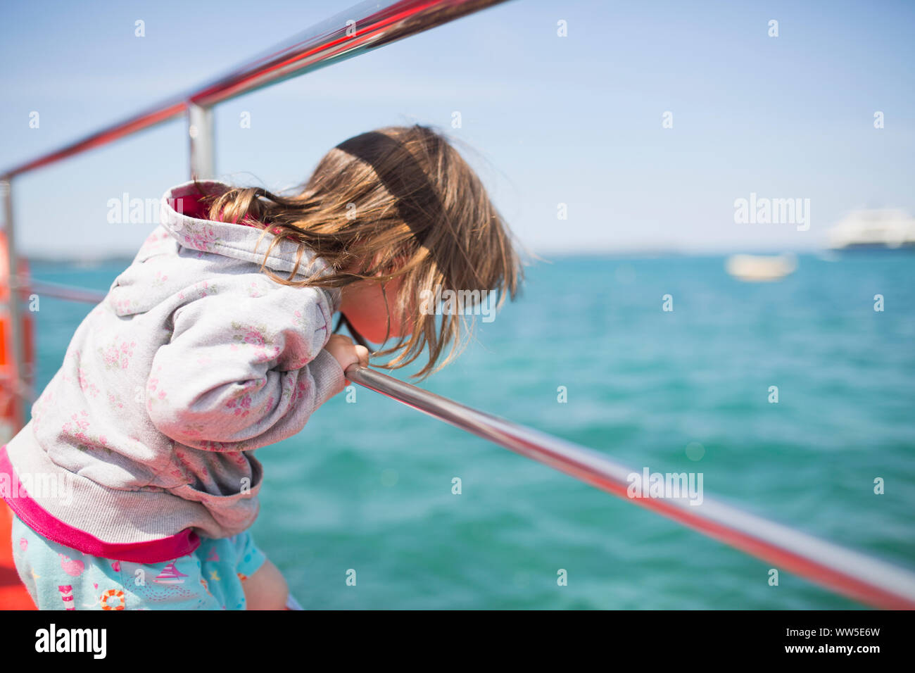 4-6 years old girl standing on a boat, view in the water Stock Photo
