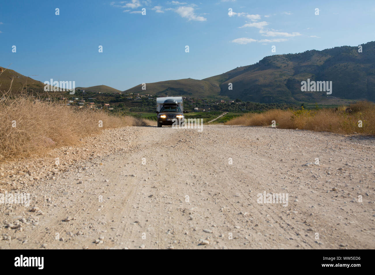 Saab with caravan driving on stony street in remote area Stock Photo