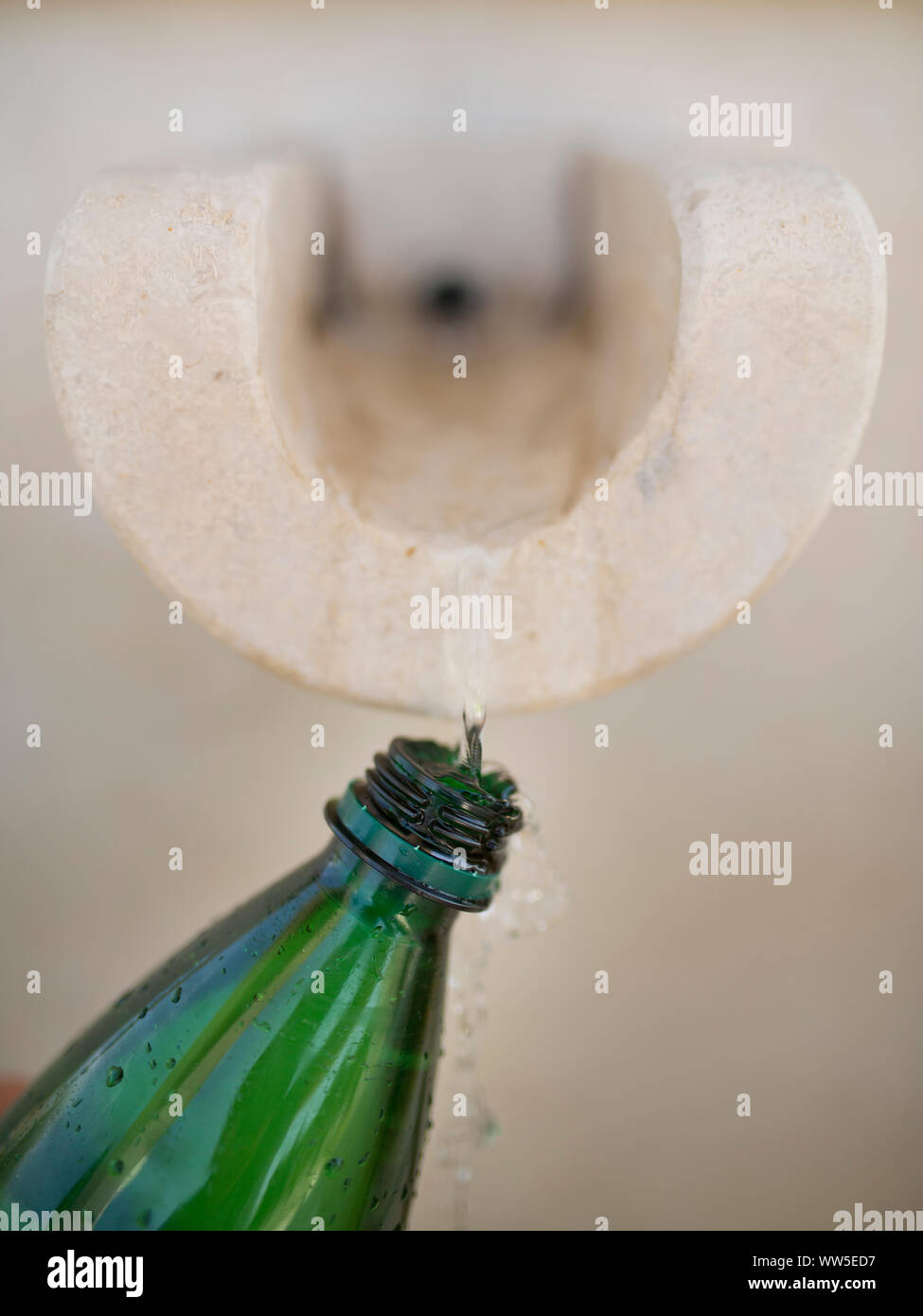 Filling water from a spring finto green PET bottle Stock Photo