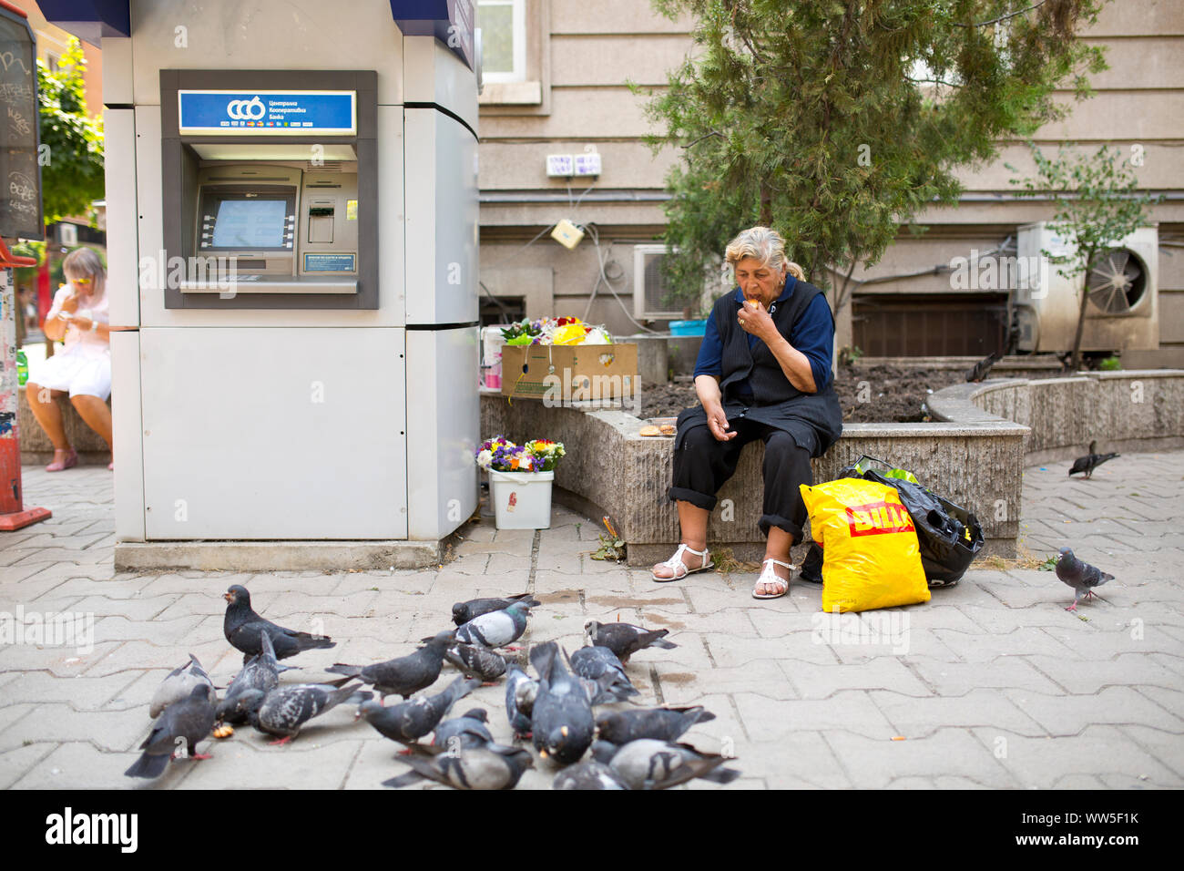 40-50 years old woman feeding pigeons in the town Stock Photo