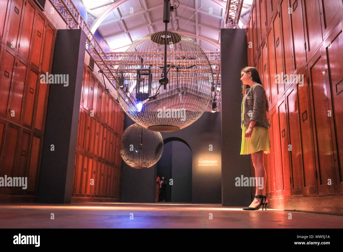 London, UK, 13th Sep 2019. An assistant engages with 'Affinity in Autonomy', an interactive installation by Sony Designs which looks at the future of AI and allows visitors to engage with a robotic pendulum. London Design Festival runs from 14-22 September 2019. Credit: Imageplotter/Alamy Live News Stock Photo