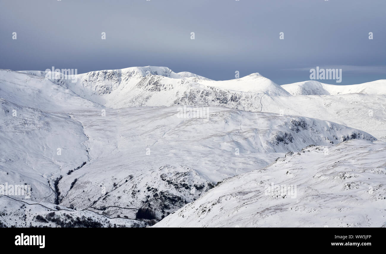 A winter snowy Lake District scene of Helvellyn, Striding Edge and Catstye Cam from Rampsgill Head near Hartsop. Stock Photo