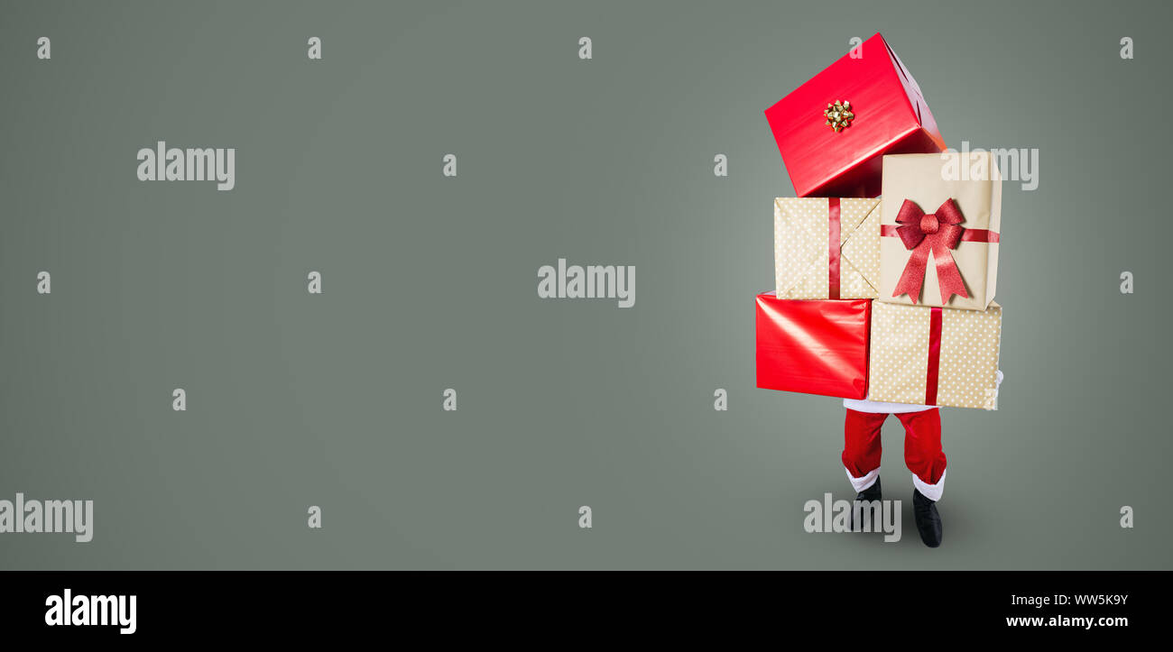 Santa Claus carrying a big Christmas presents in his hands Stock Photo