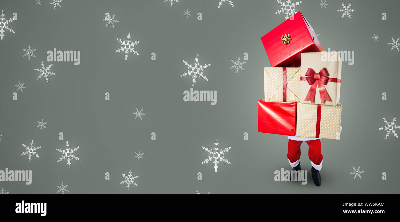 Santa Claus carrying a big stack of Christmas gifts Stock Photo - Alamy