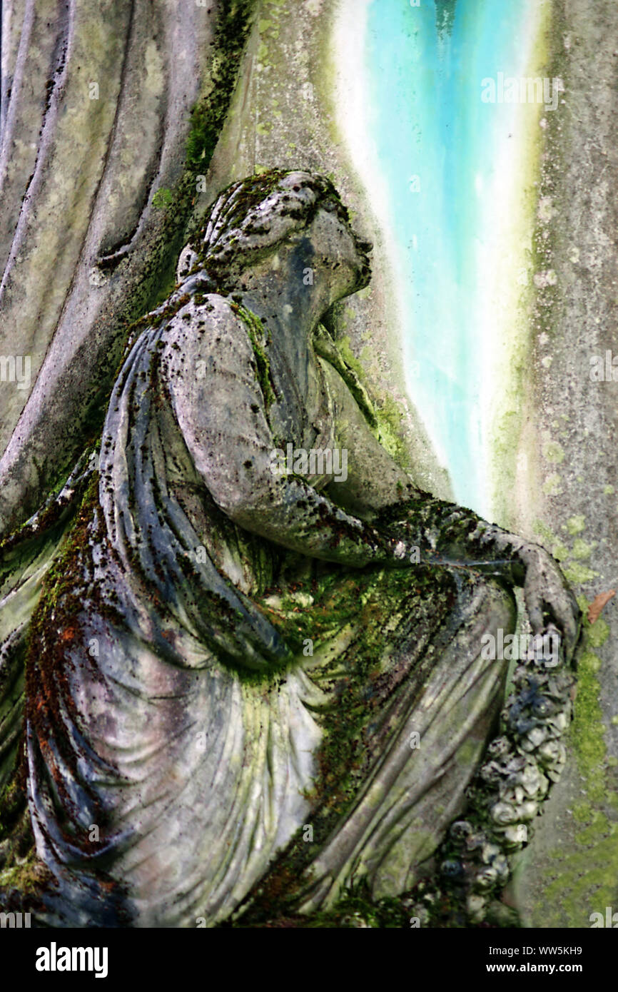 Sculpture of a suffering sitting woman covered with moss by an unknown artist in Wiesbaden, Stock Photo
