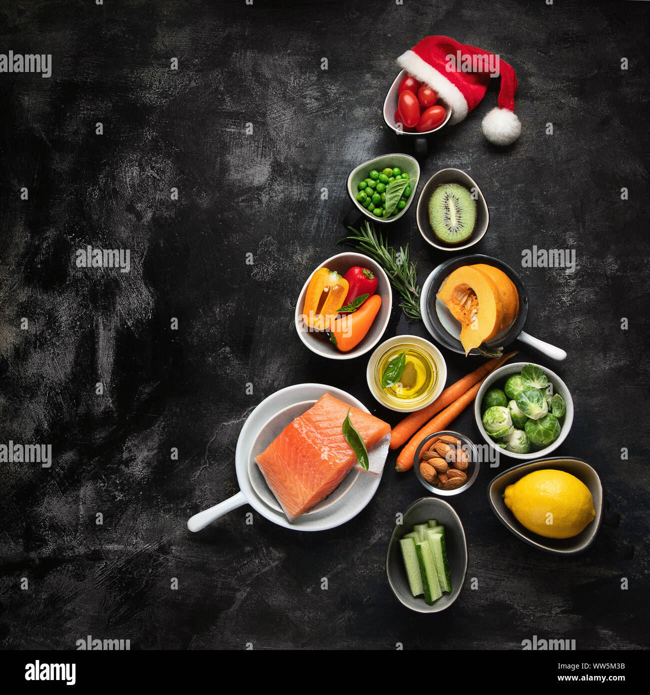 Christmas tree made of healthy food on black background. Top view with ...