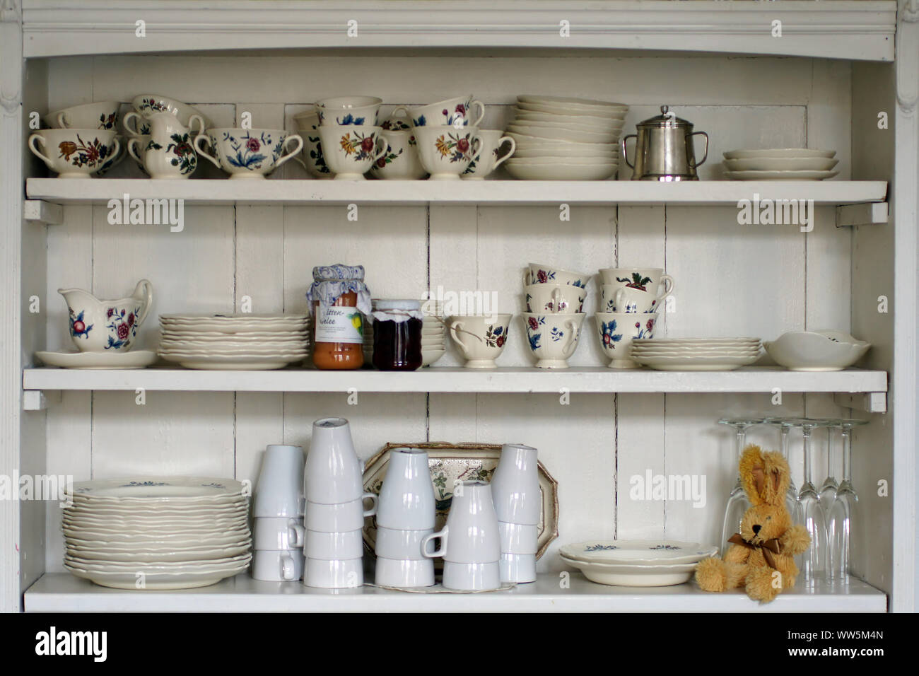 Photography of an old kitchen shelf with cups and plates hires stock