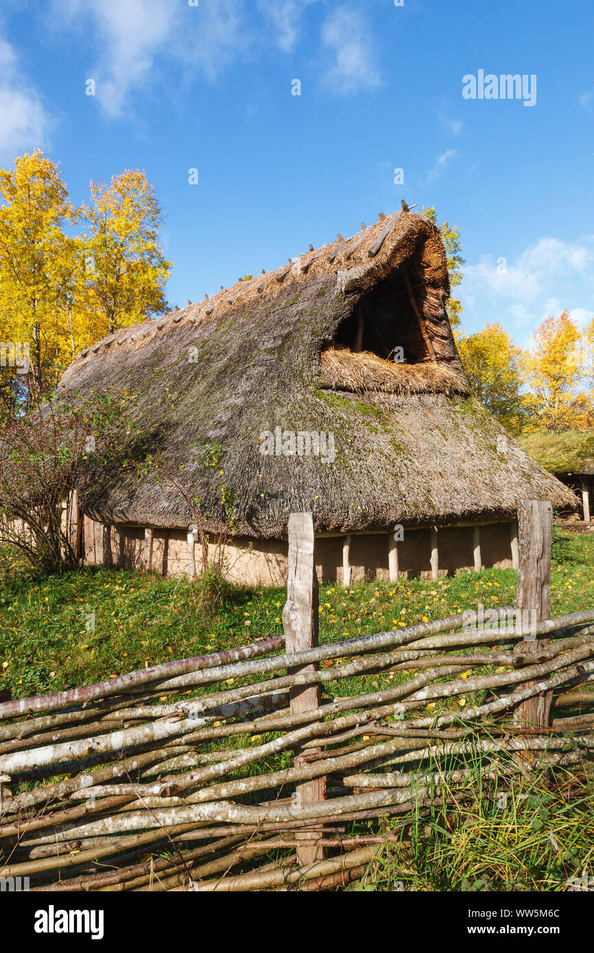 Long house with a branch braided fence in autumn Stock Photo