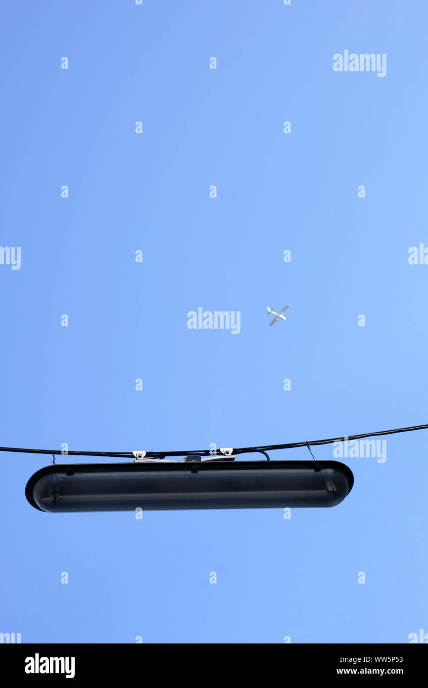Photography of a hanging street lamp with airplane above, Stock Photo