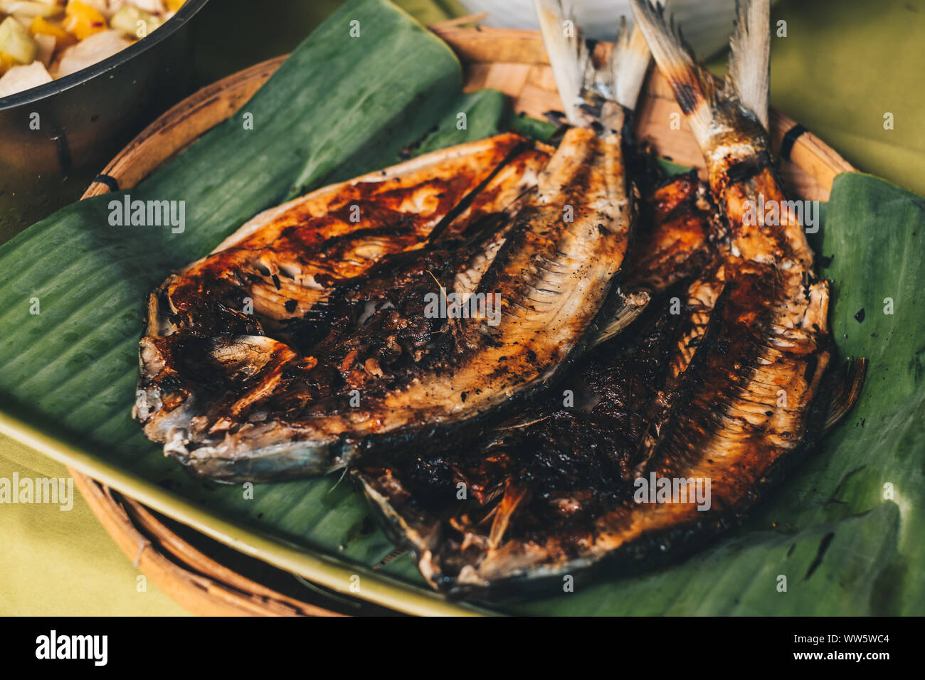 Popular Filipino dish of two grilled milkfish on aromatic banana leaf during celebration