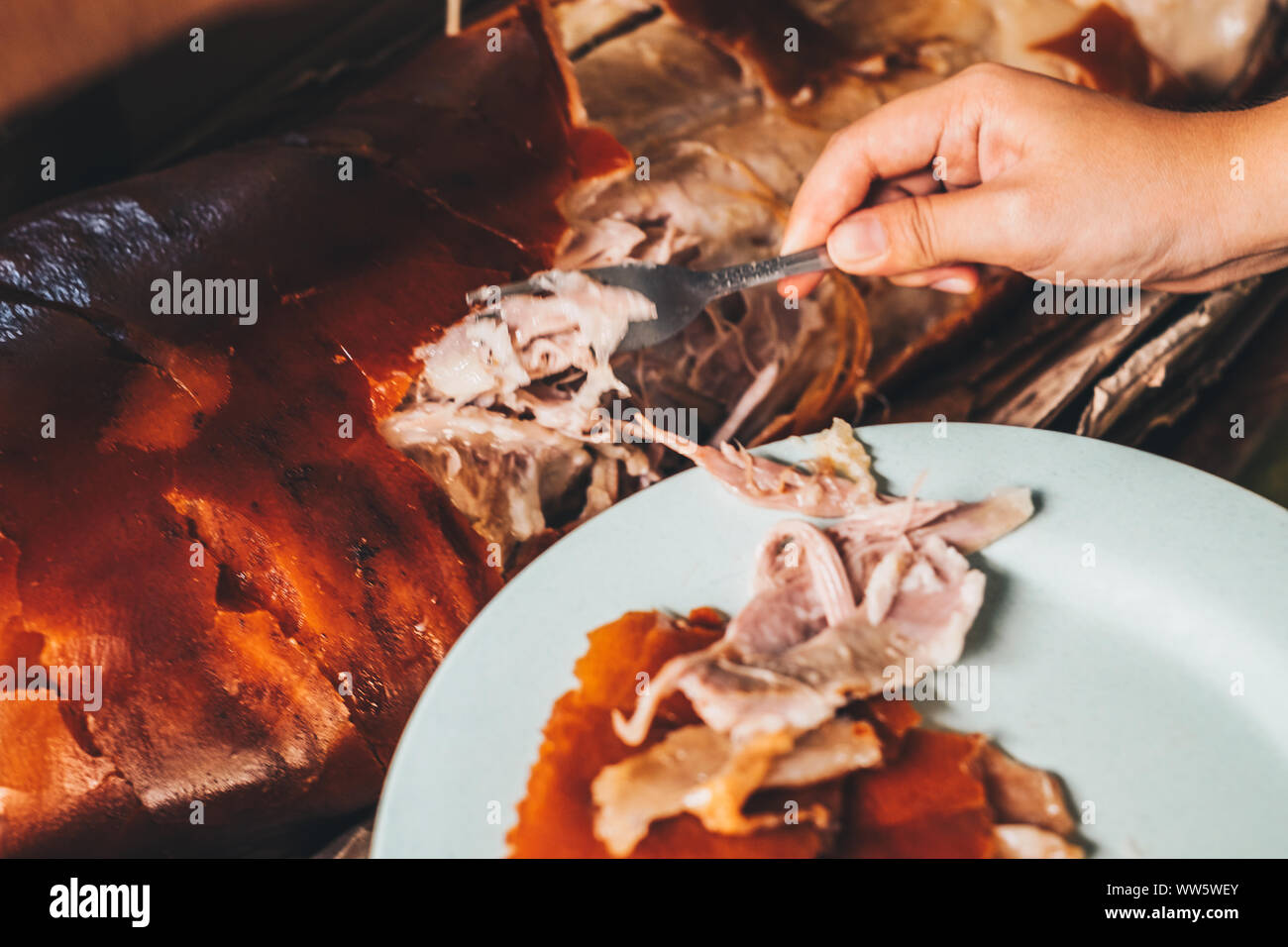 lechon high resolution stock photography and images alamy https www alamy com hand getting a piece of the popular and delicious roasted pig or lechon baboy using fork selective focus image273651699 html