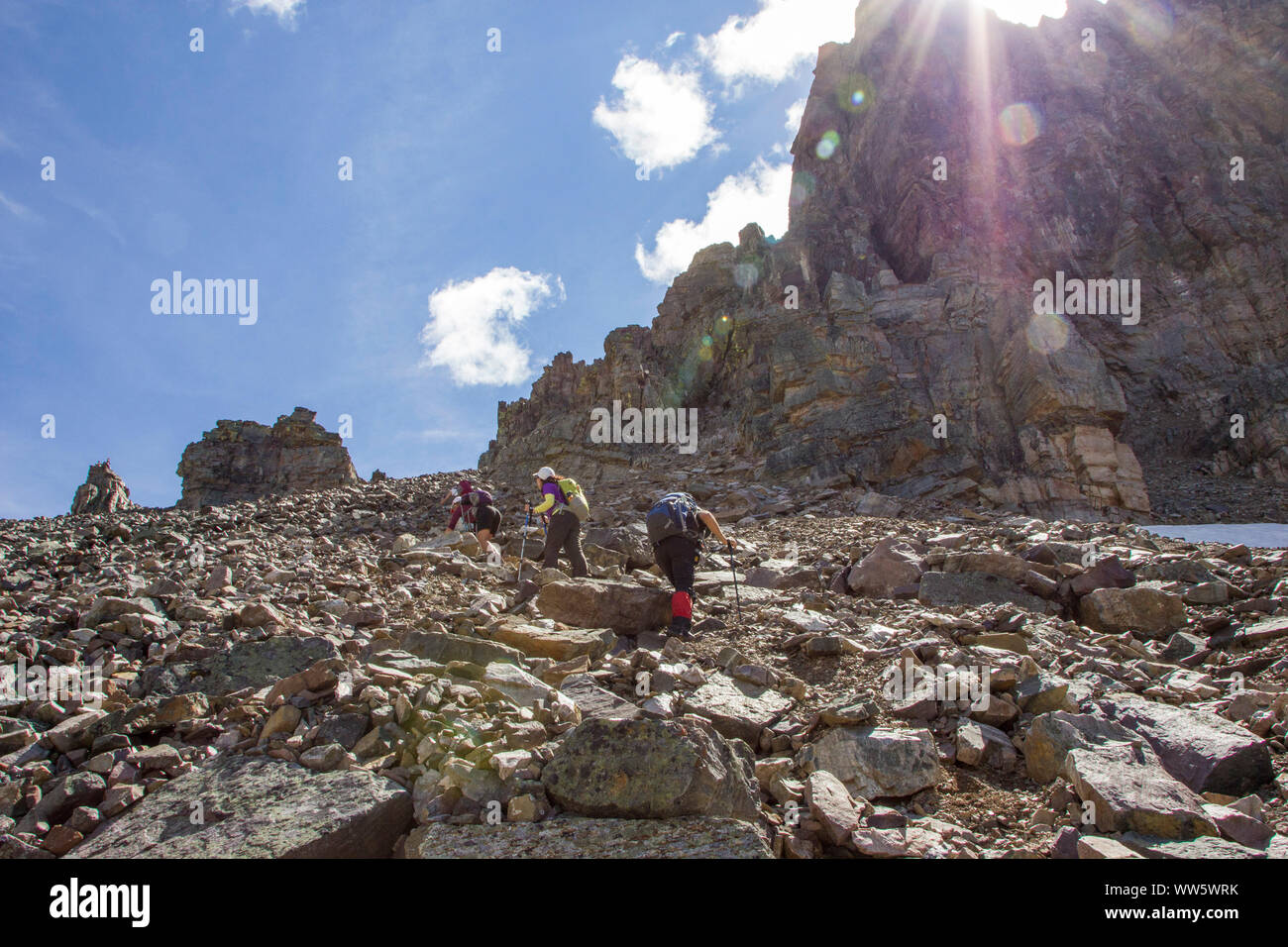 Hikers climbing a scree field, Rocky Mountains Stock Photo