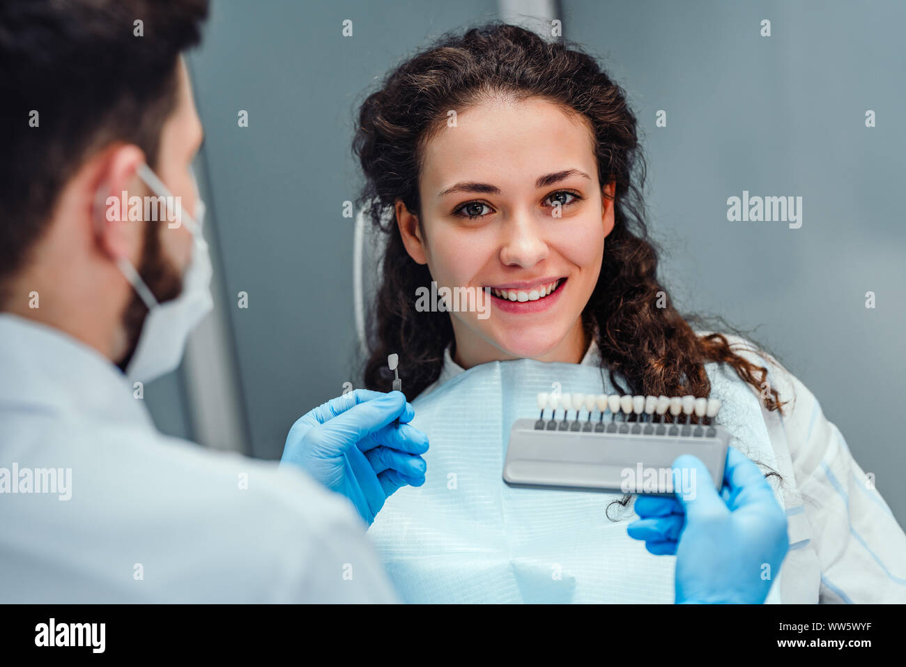 Choice of tooth color with a special scale. Dentist select a shade of