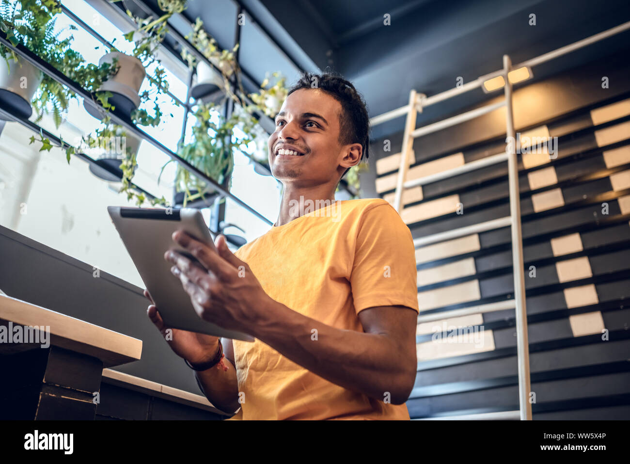 Man using his tablet in a coffee shop. Stock Photo