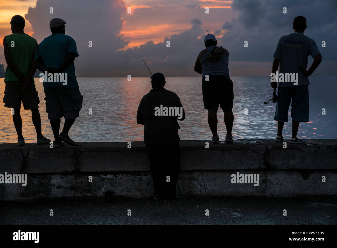 Angler as a silhouette at the Malecon in Havana, evening mood, orange and violet colours Stock Photo