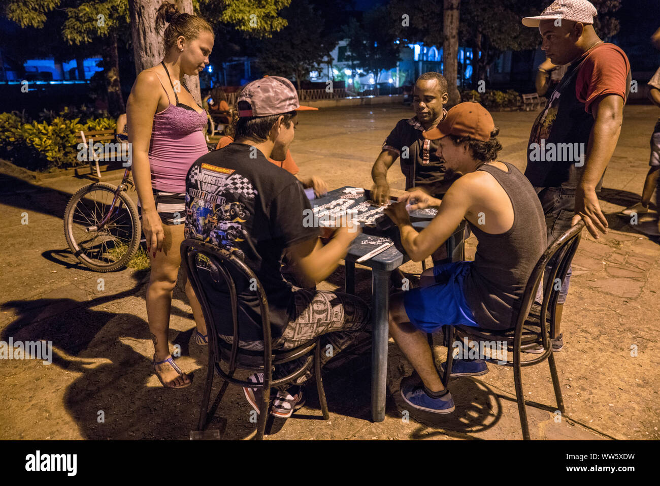 Dominoes player sitting at a lukewarm night on the churchyard square in ViÃ±ales, people watching Stock Photo