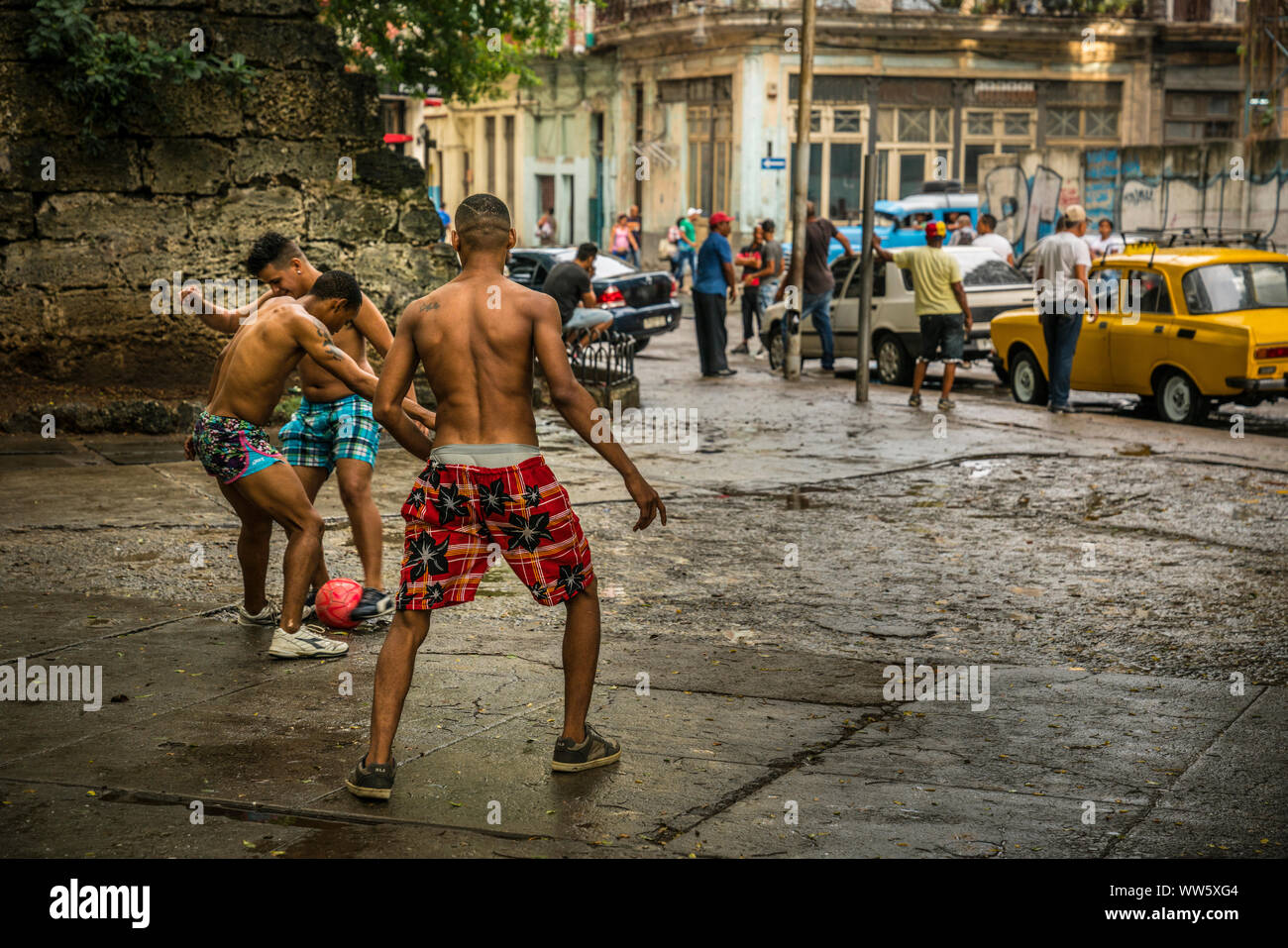 Young men playing football on the street, Havana, Cuba Stock Photo