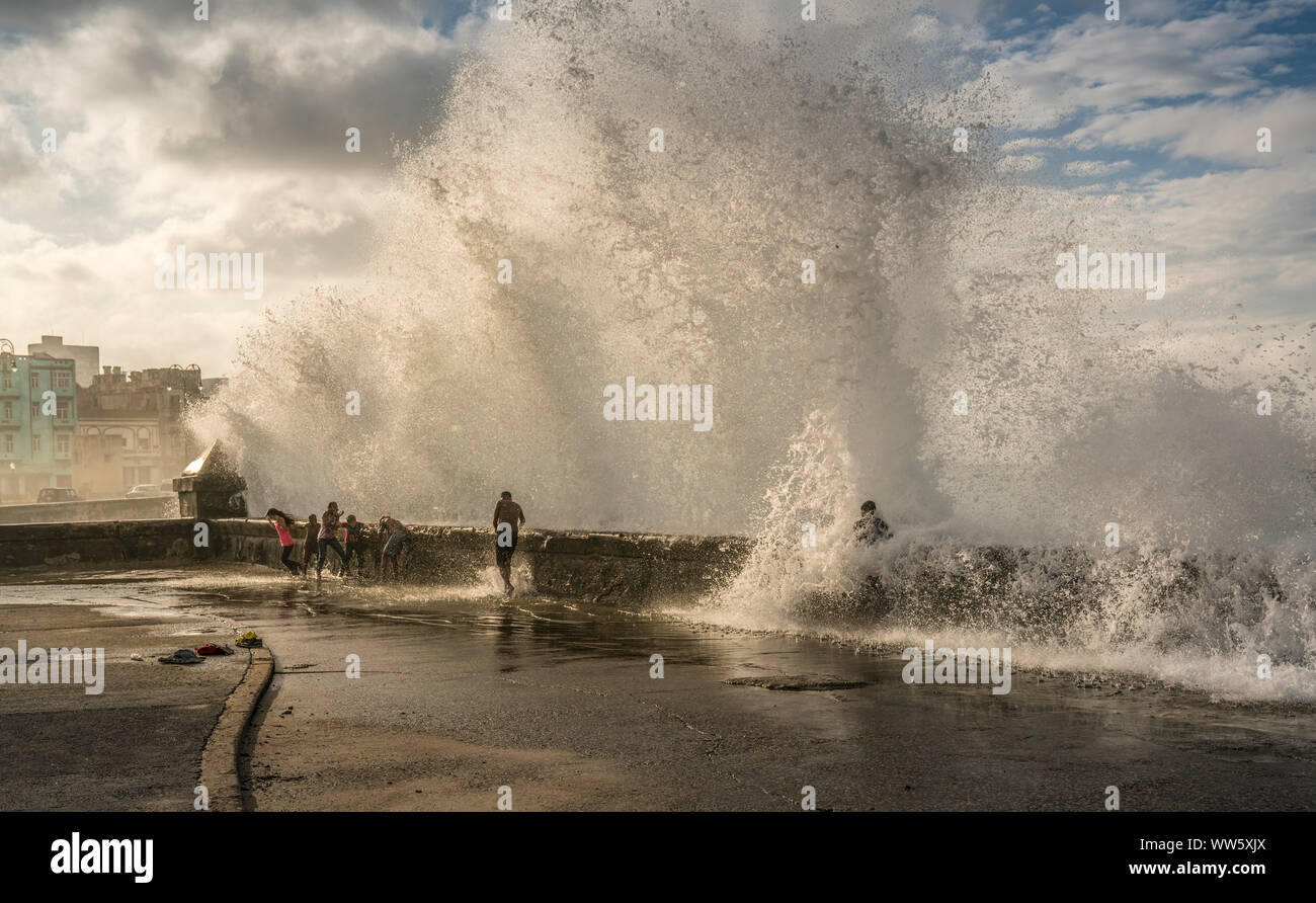 A wave hitting above the Malecon in Havana, Cuba, wave splashing on children, Stock Photo