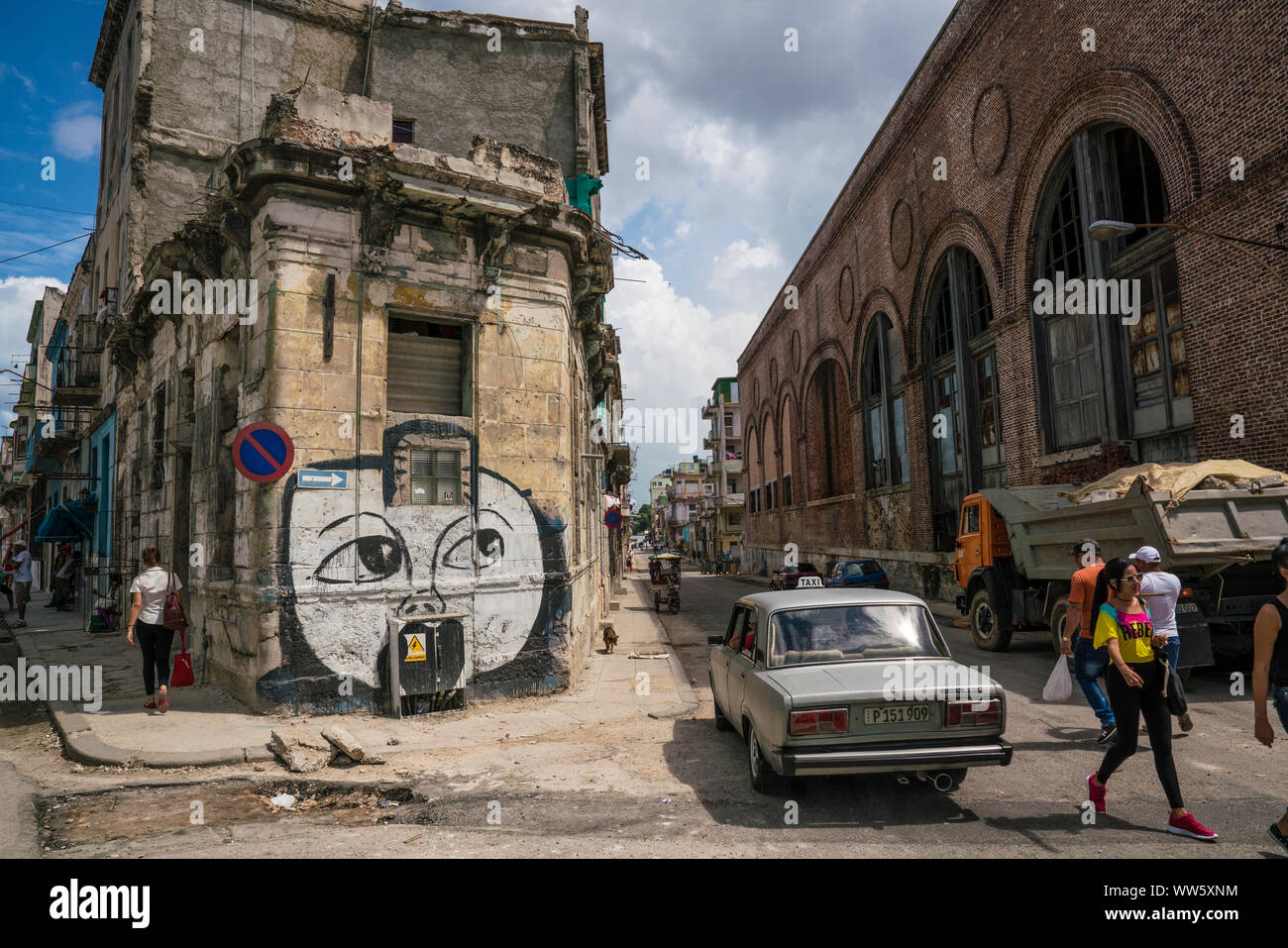 Graffiti at a house facade in Havana, a car and pedestrian Stock Photo