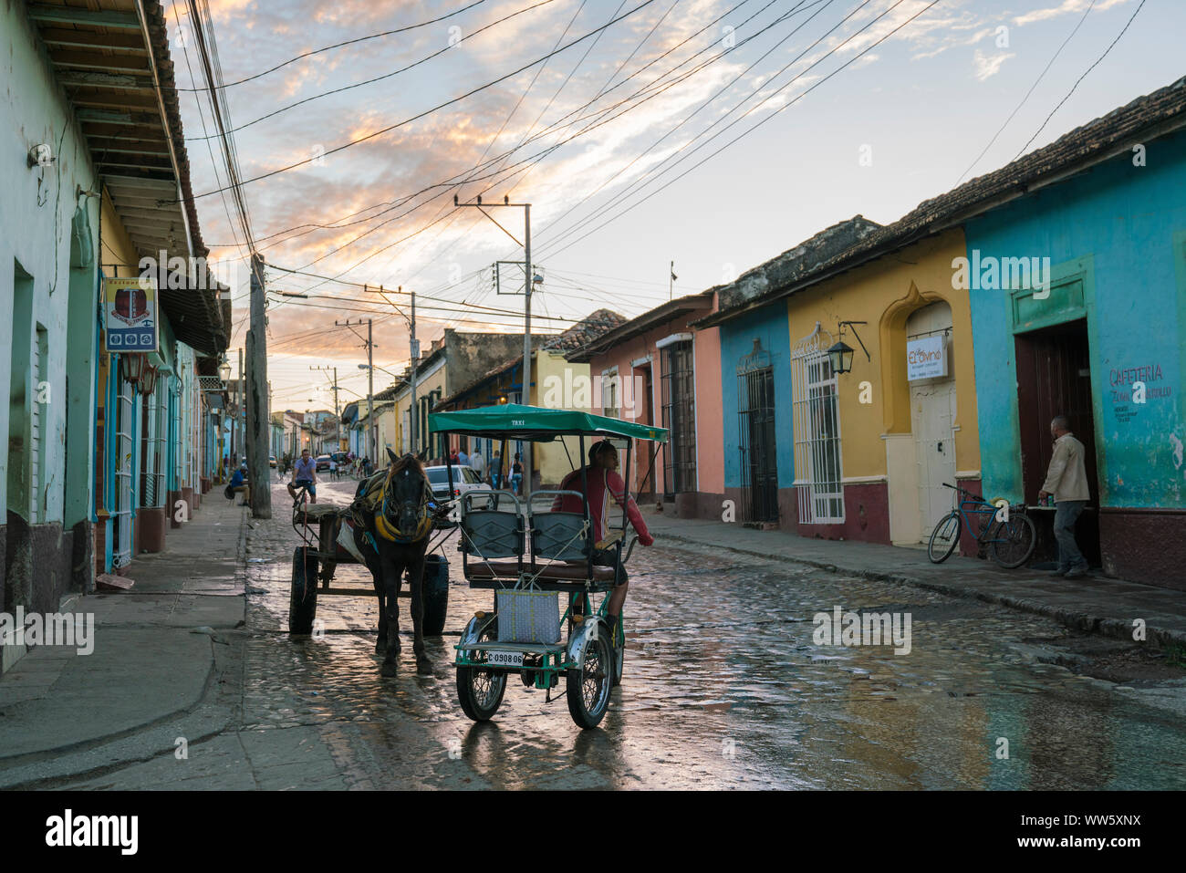 Junction with bicycle taxi and horse cart in Trinidad, Cuba, sunrise, coloured houses Stock