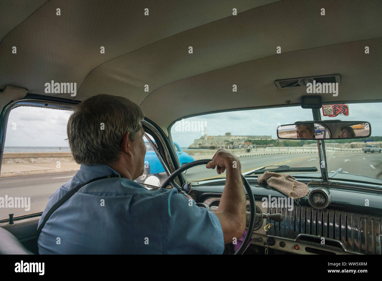 Vintage car taxi from the inside with driver and view at El Morro, Cuba Stock Photo