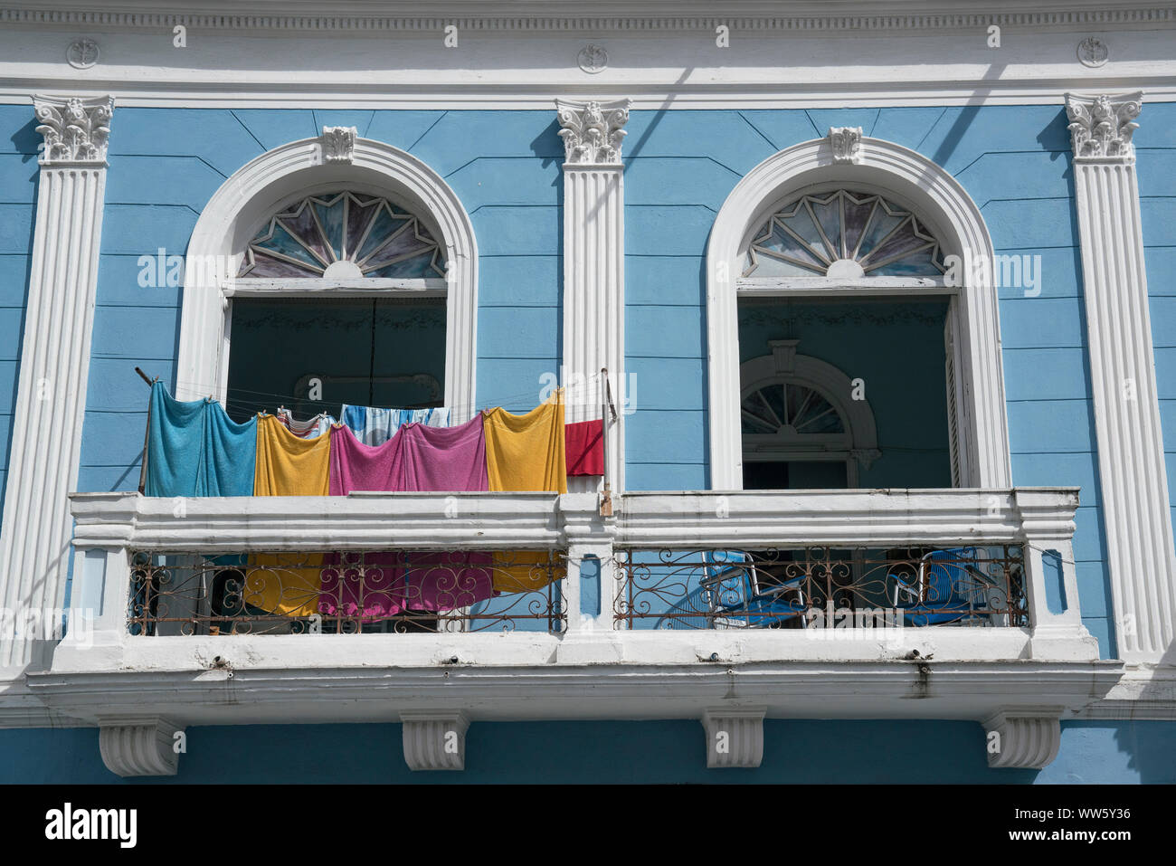 Laundry drying on a balcony of a blue house in colonial style, Santiago de Cuba Stock Photo