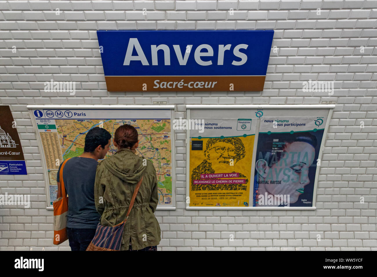 France, Paris, man, woman, metro route map, advertisement, station sign, Anvers, SacrÃ©-CÅ“ur Stock Photo