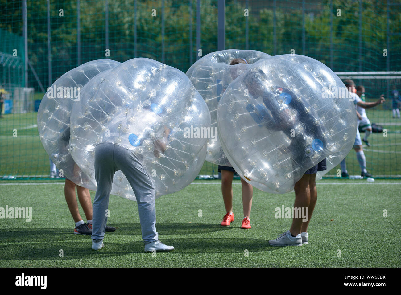 Bubble football. People in bubble inside putting heads together before