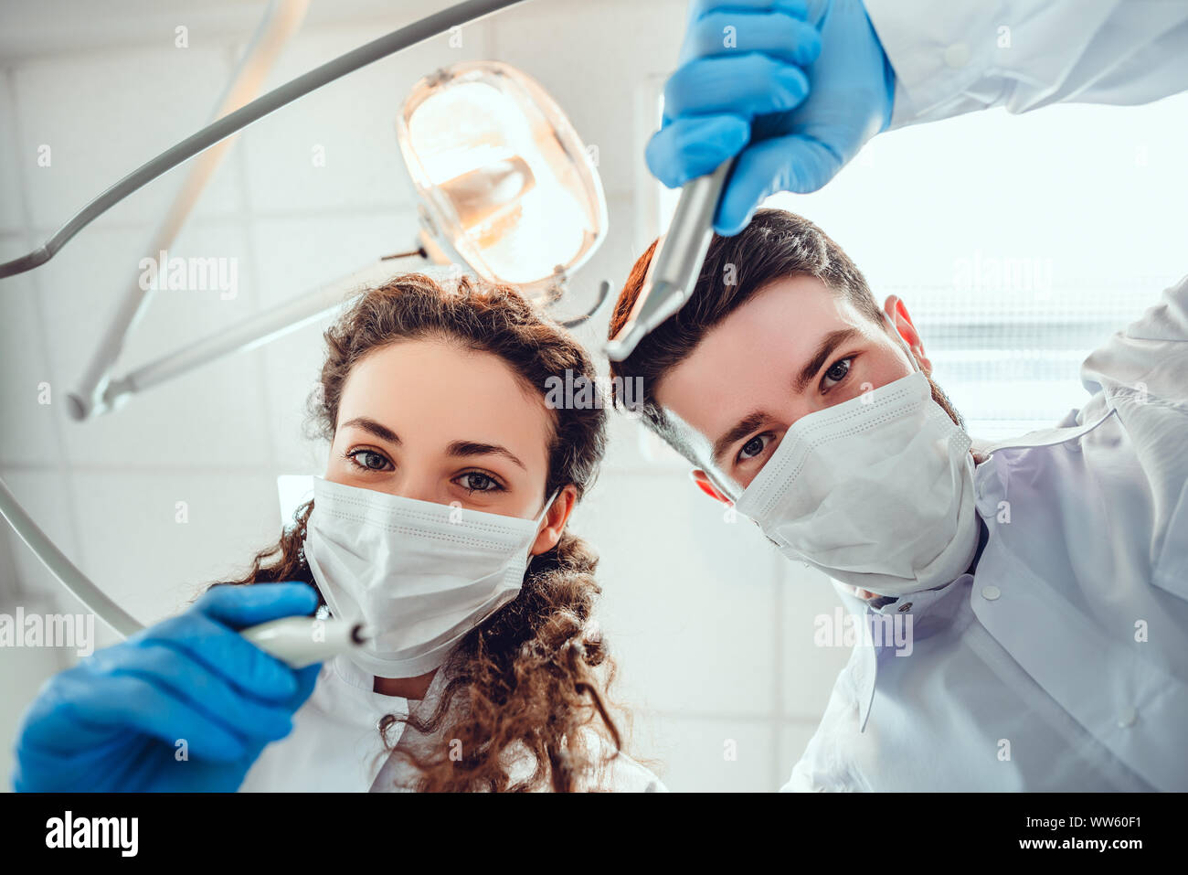 Low angle portrait of male and female dentists wearing masks at dental