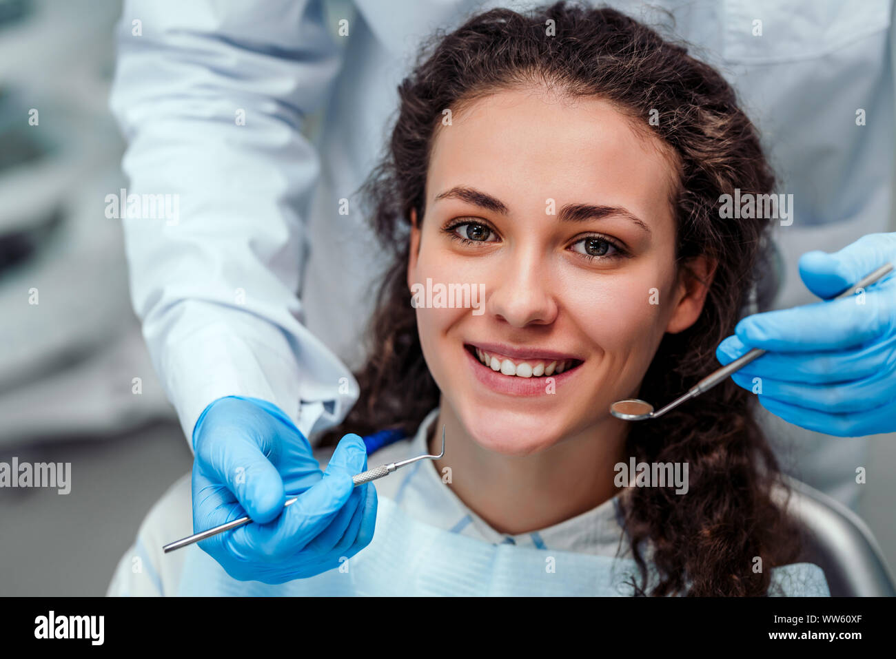 Health check. Dentist in stomatology center is making an examination of girl teeth by using dental tools. Stock Photo