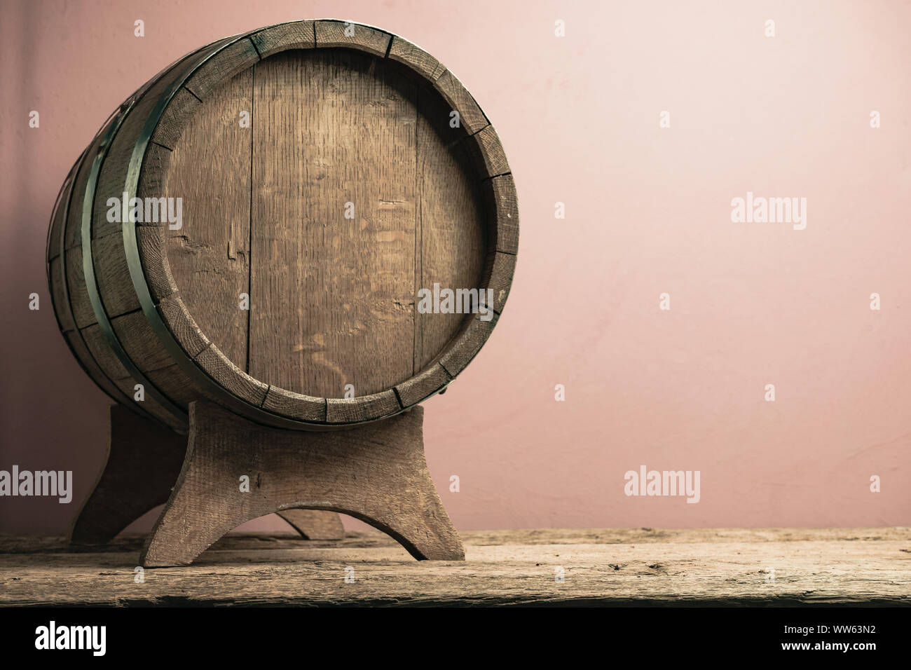 Beautiful wooden barrel on a old oak table and red wall background