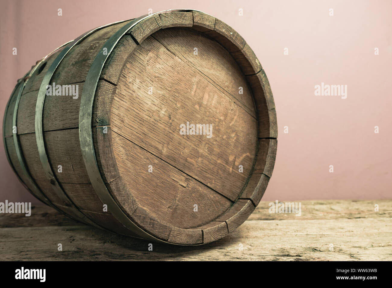 Beautiful wooden barrel on a old oak table and red wall background