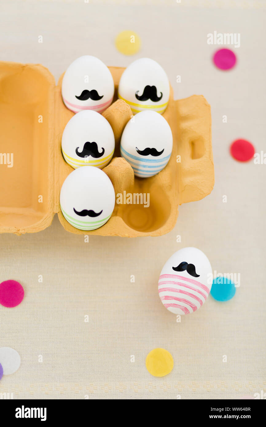 Easter eggs with moustache, egg carton, colour spot Stock Photo