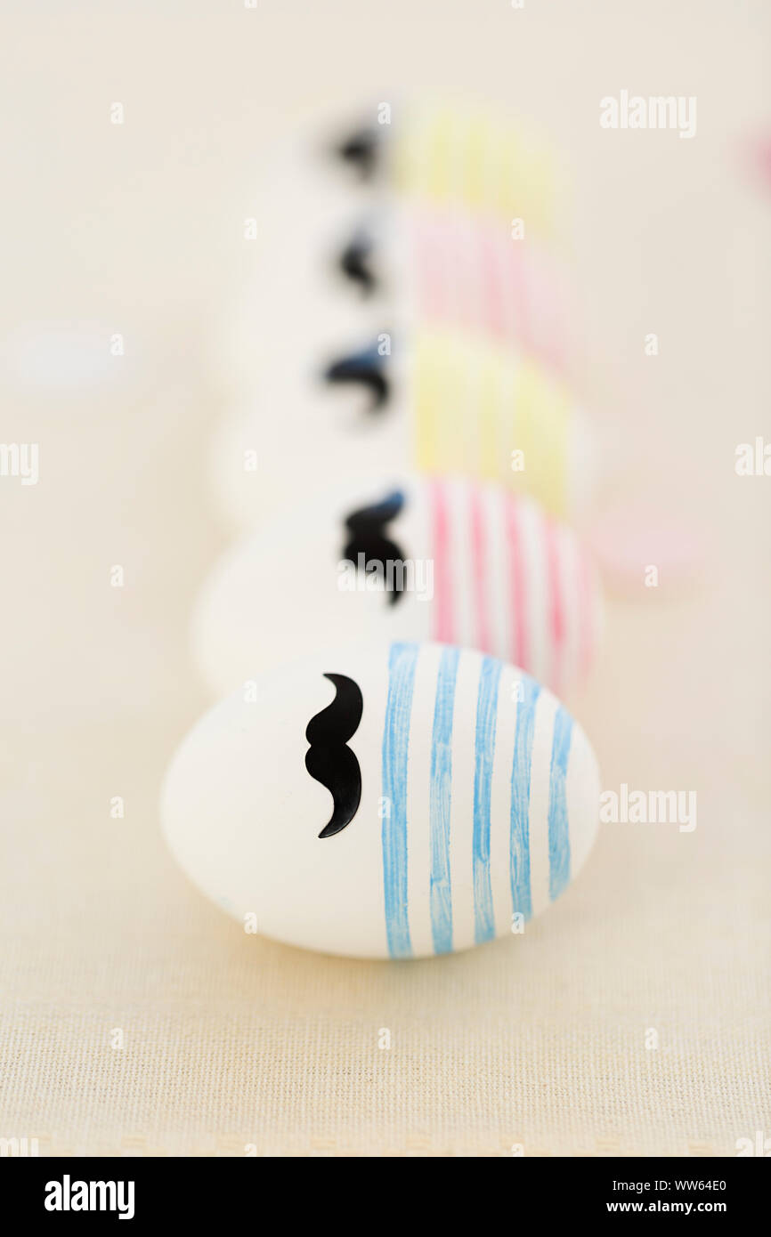Line-up, row of Easter eggs with beard, colourful Stock Photo