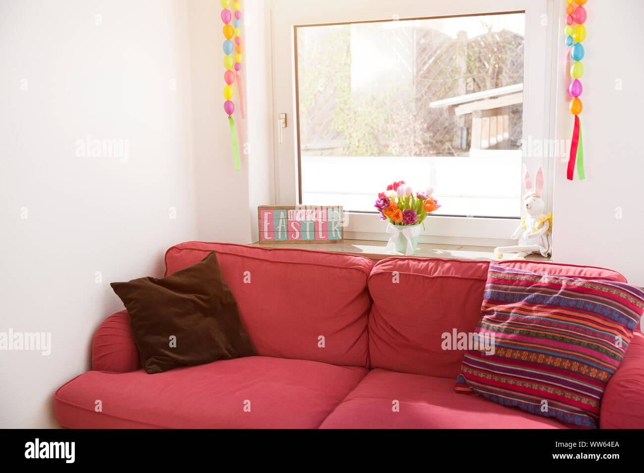 Easter decoration, living room, couch, window, backlight Stock Photo