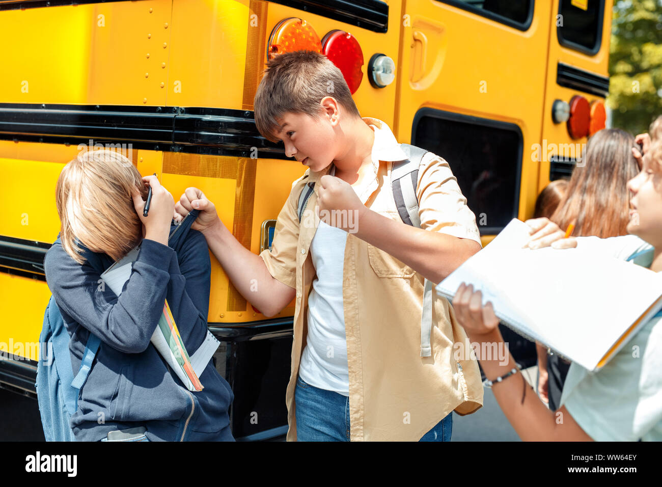 Children going to school by bus boys bullying classmate aggressive