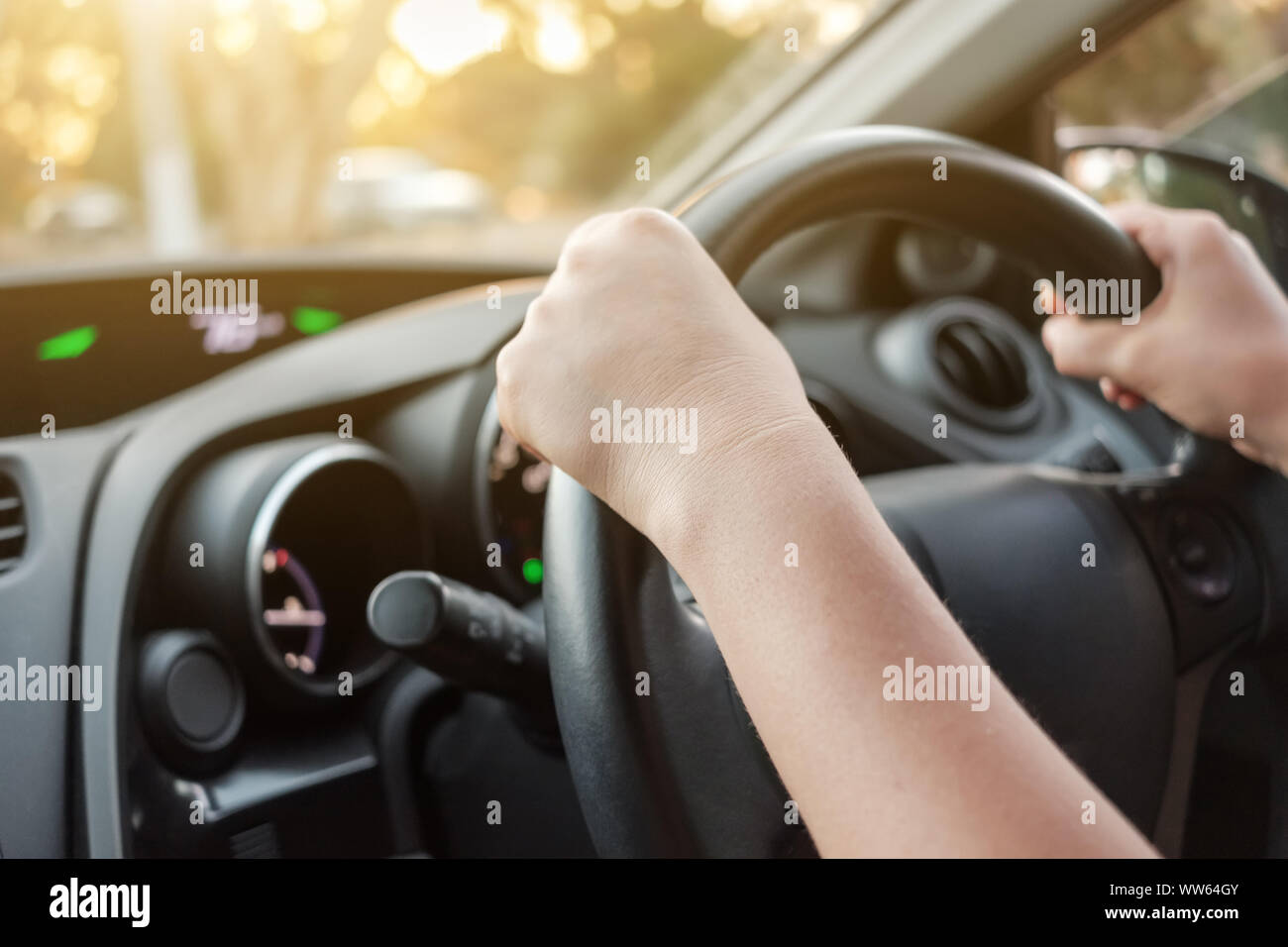 Woman driving her car with both hands on steering wheel Stock Photo