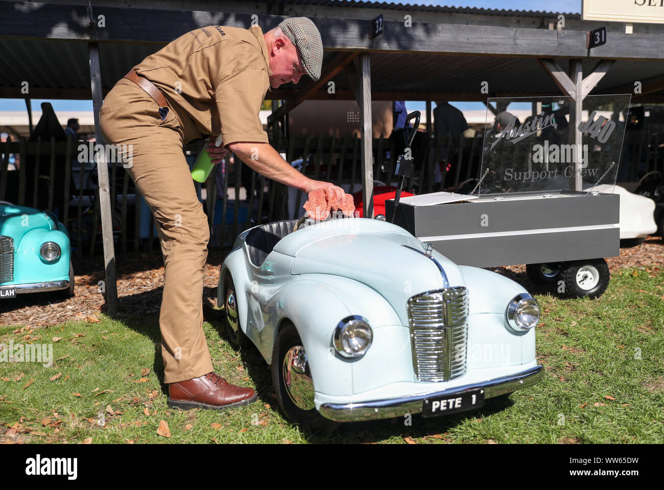 A valet polishes an Austin J40 pedal car during day one of the Goodwood Revival at the Goodwood Motor Circuit, in Chichester. Stock Photo
