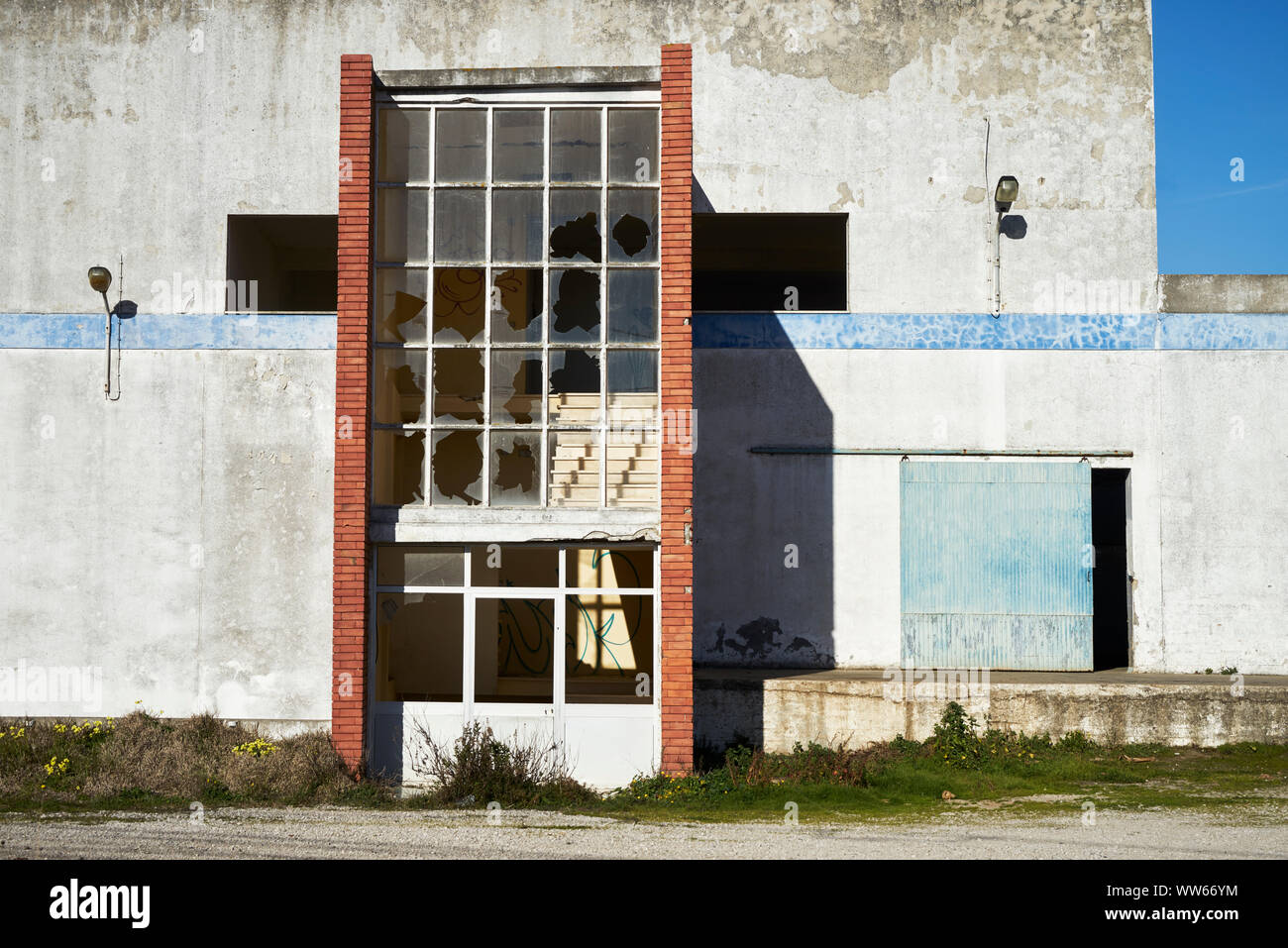 Old warehouse with red brick wall and smashed windows Stock Photo