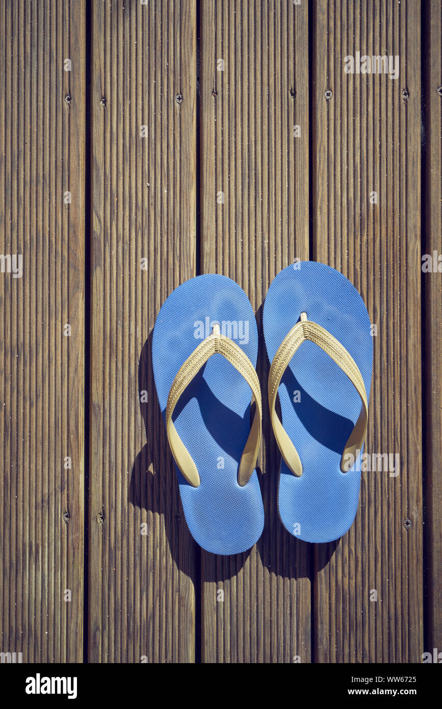 Blue flip flops on brown wood, from above Stock Photo