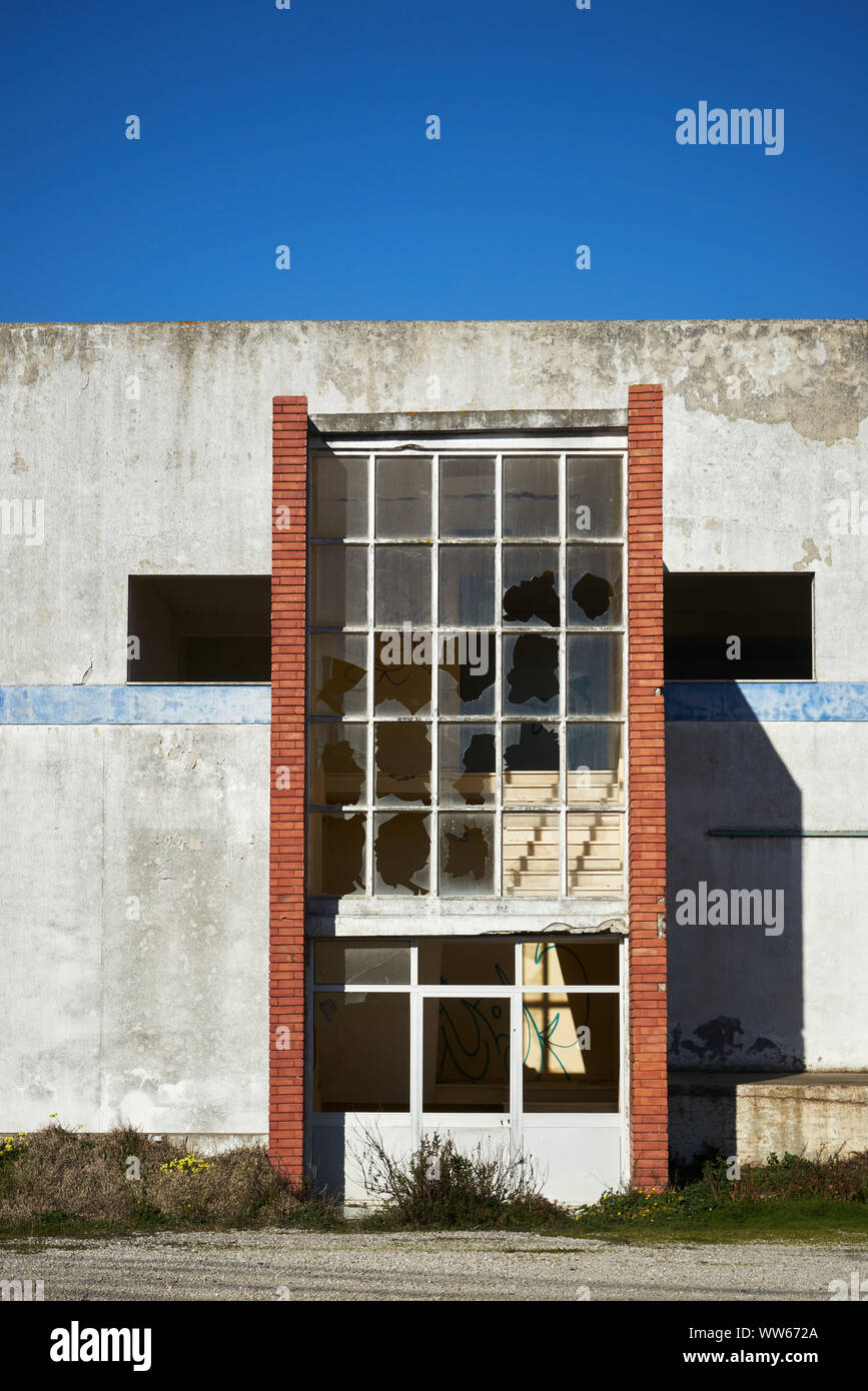 Old warehouse with red brick wall and smashed windows Stock Photo