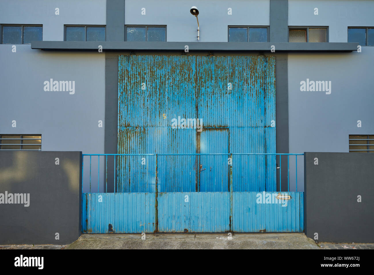 Blue factory building, gate closed Stock Photo