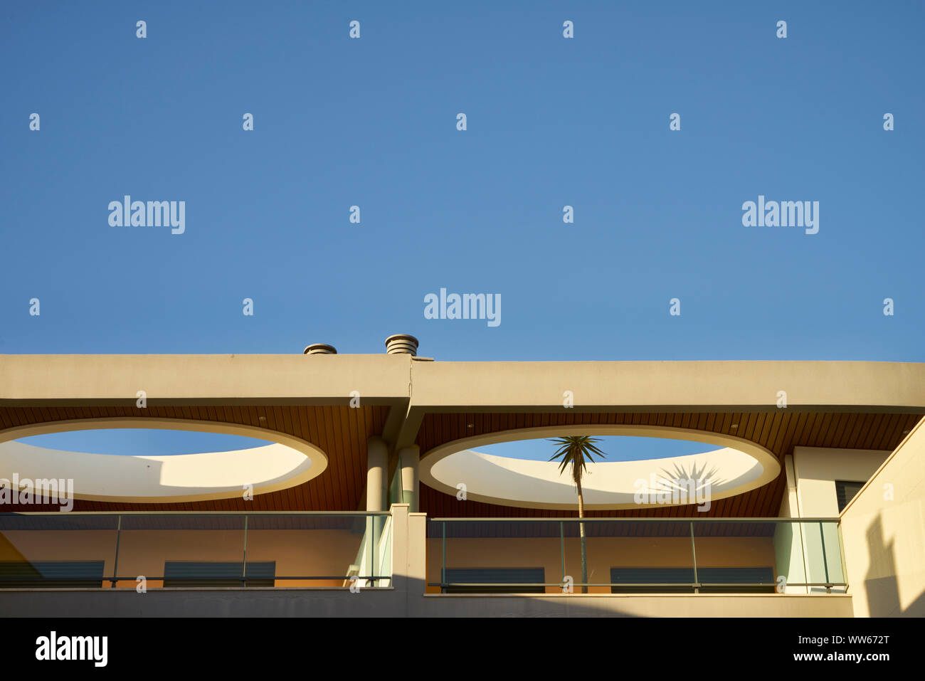 Apartment with balcony from below against blue sky, Mediterranean Stock Photo