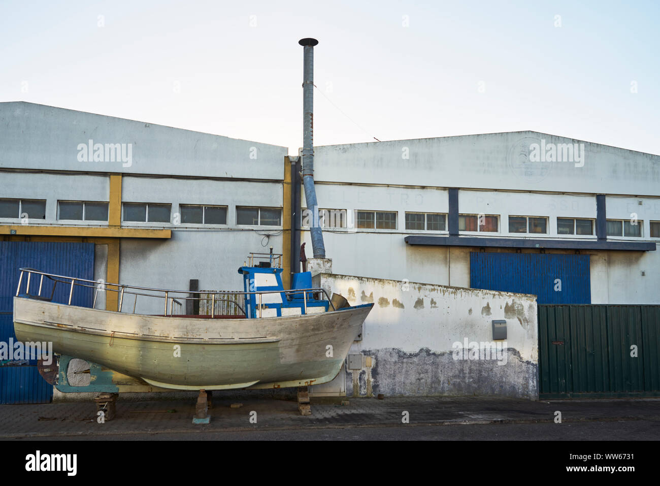 Old boat beside factory building Stock Photo