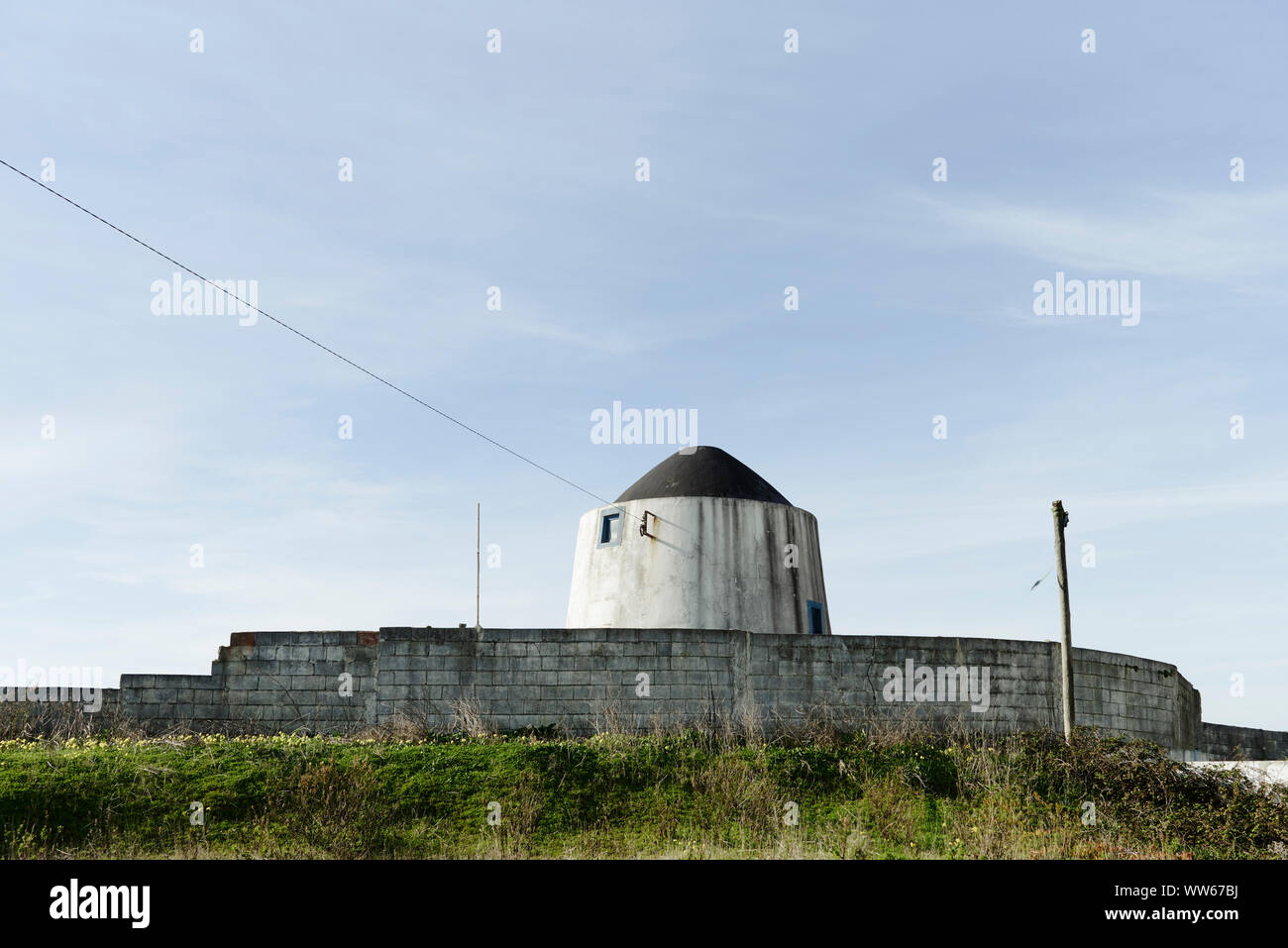 old windmill with wall, blue sky with clouds Stock Photo