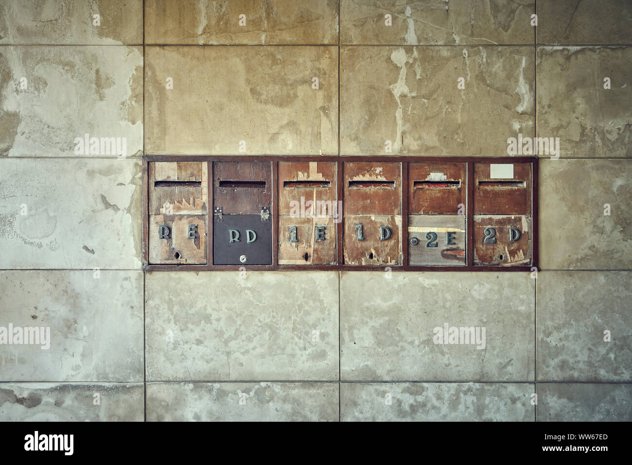 six different old mailboxes at the entrance of a house Stock Photo