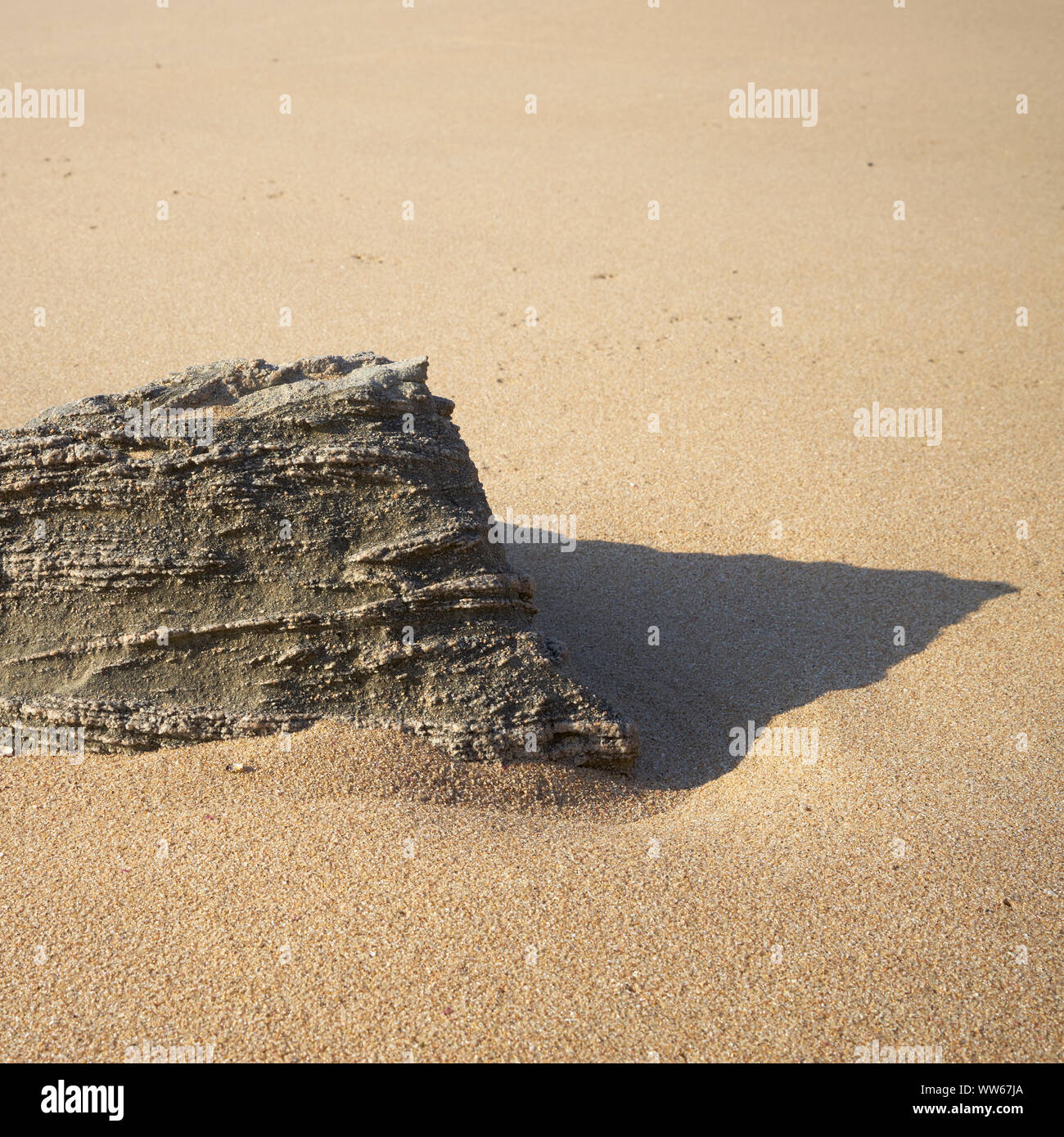 Beach with rock in the foreground and shadow Stock Photo