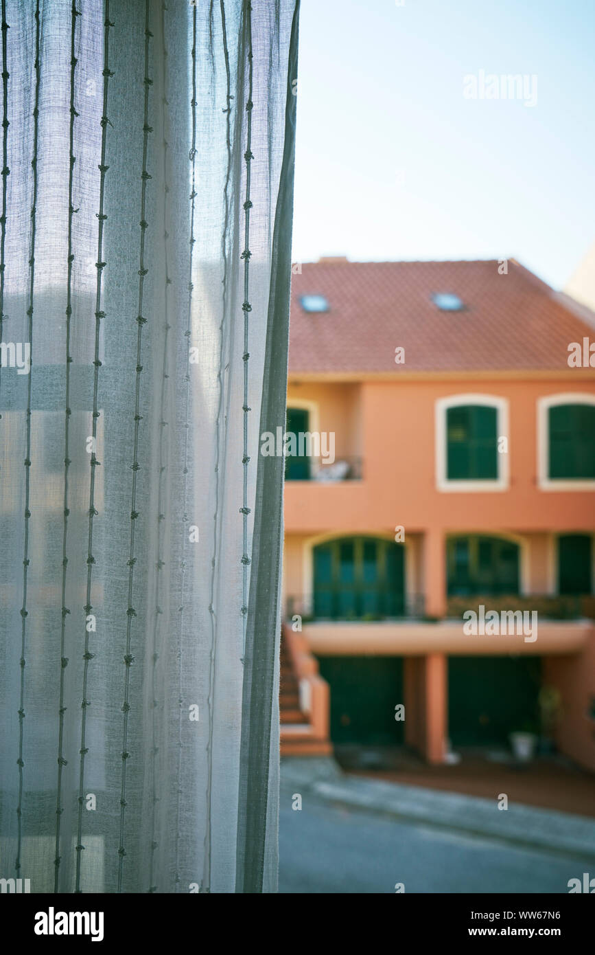View from the window with open curtain to the neighbouring house, street and stairs Stock Photo