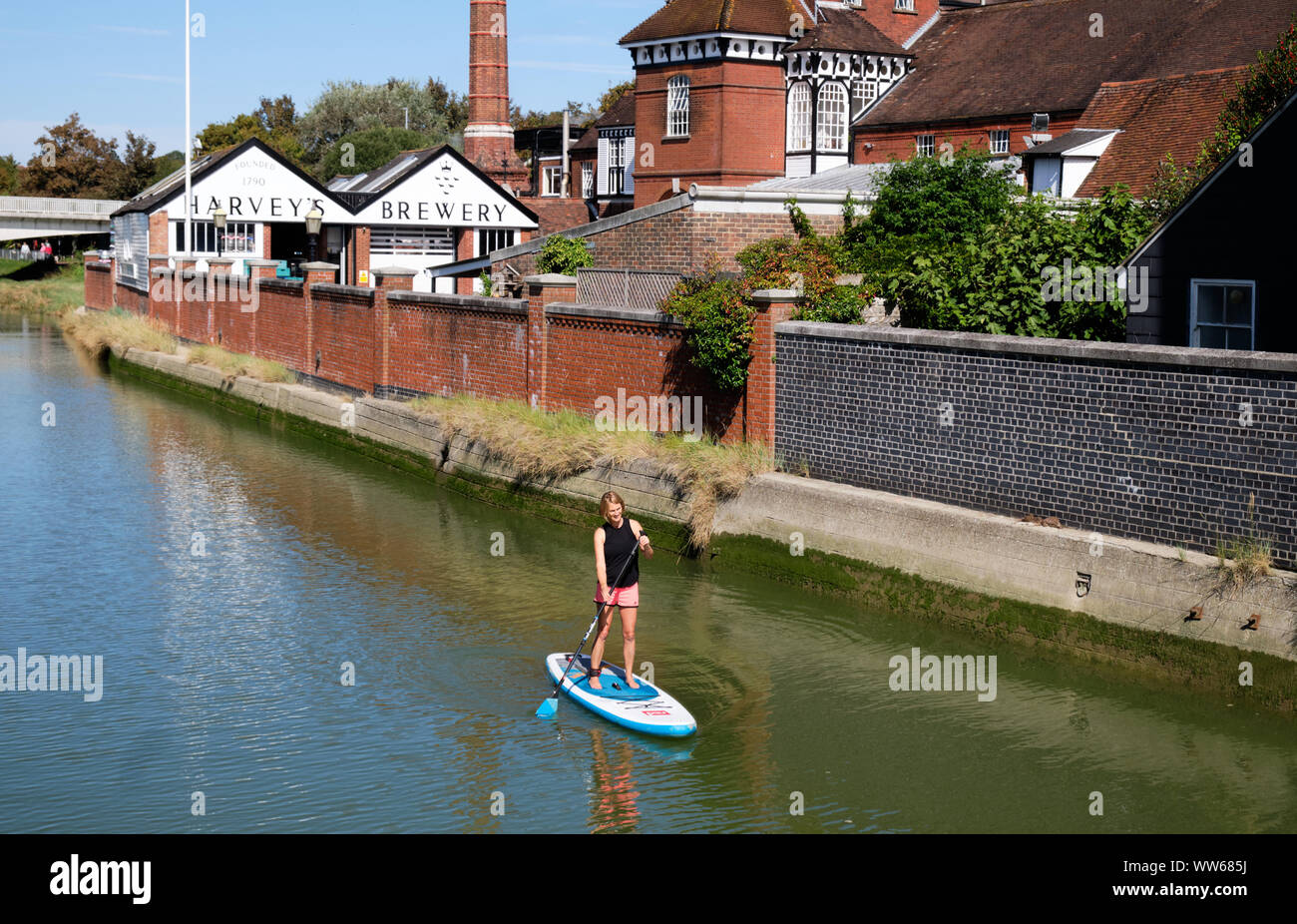 Lewes, East Sussex, UK. 13th September, 2019. UK Weather: Beautiful sunny afternoon in Lewes with temperature reaching 20 degrees, as a paddle border takes advantage of the return of the sun to go through the town on the Ouse river passing by Harvey's Brewery . Stock Photo